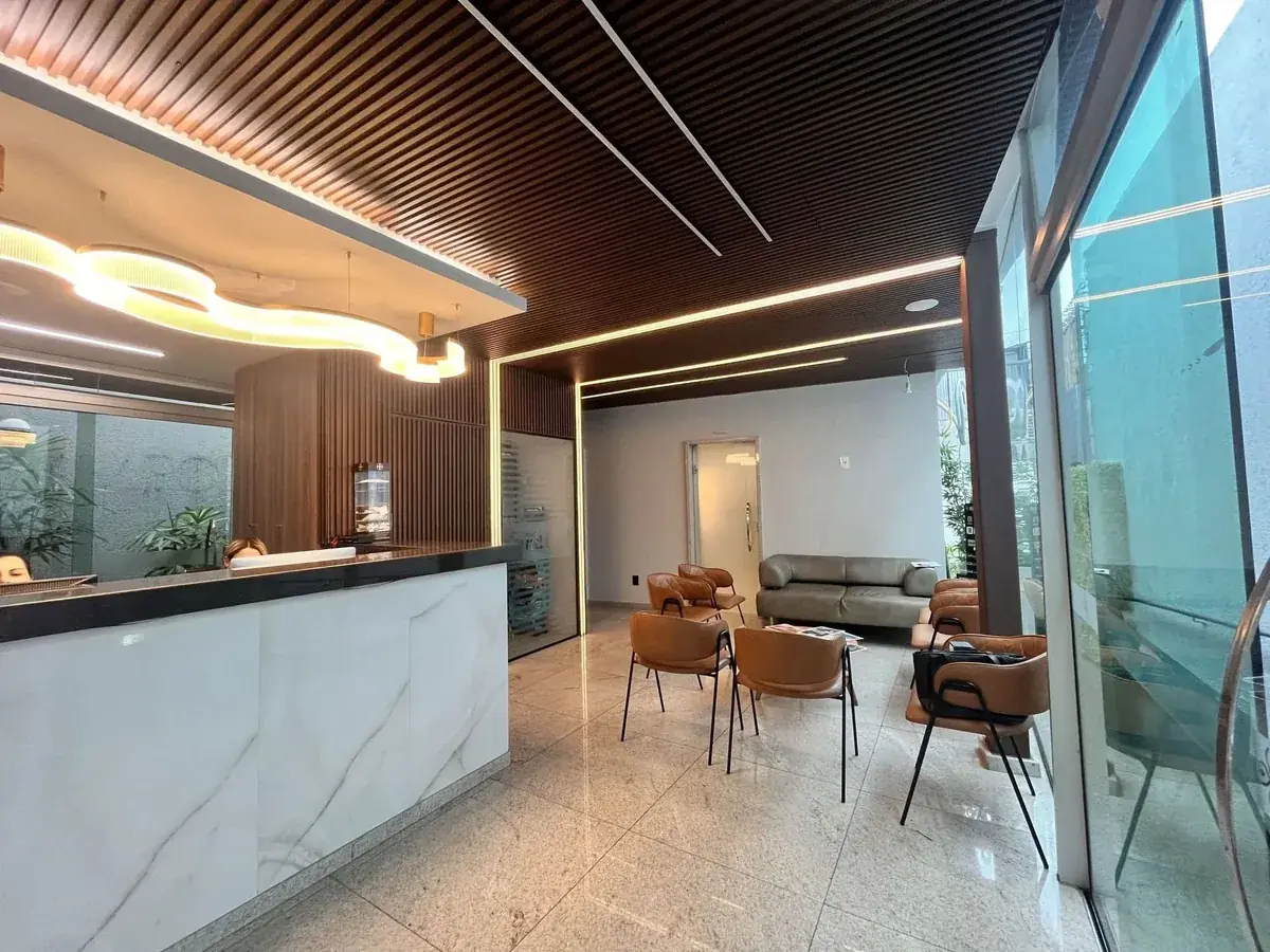 Recepção da Clínica Feel Better com painel ripado de madeira e fitas de LED